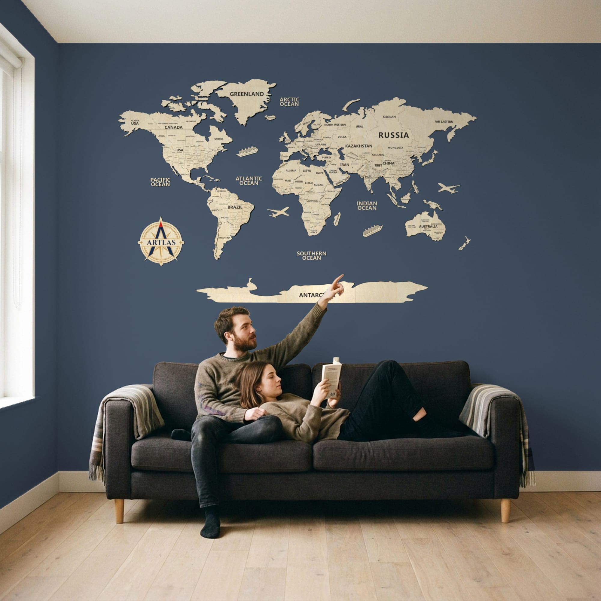 Two people on a sofa beneath the map in birch