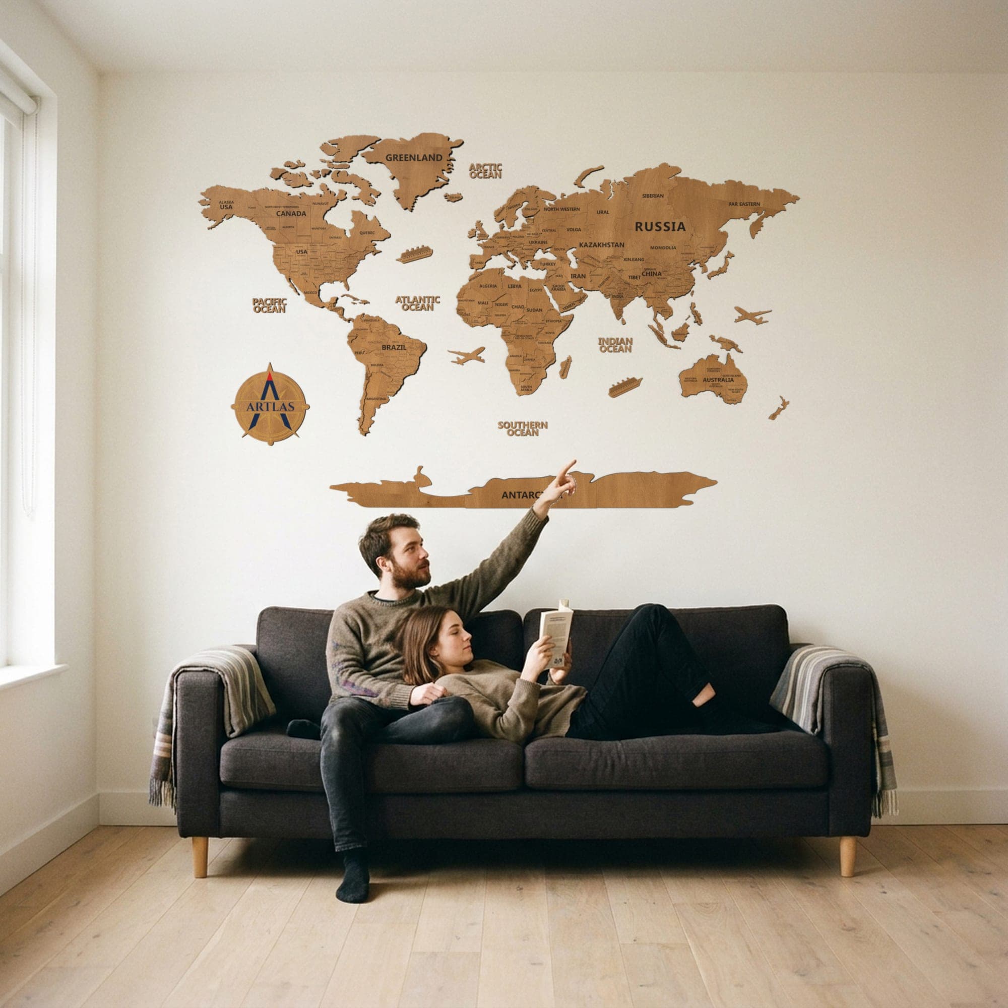 Two people on a sofa beneath the map in teak