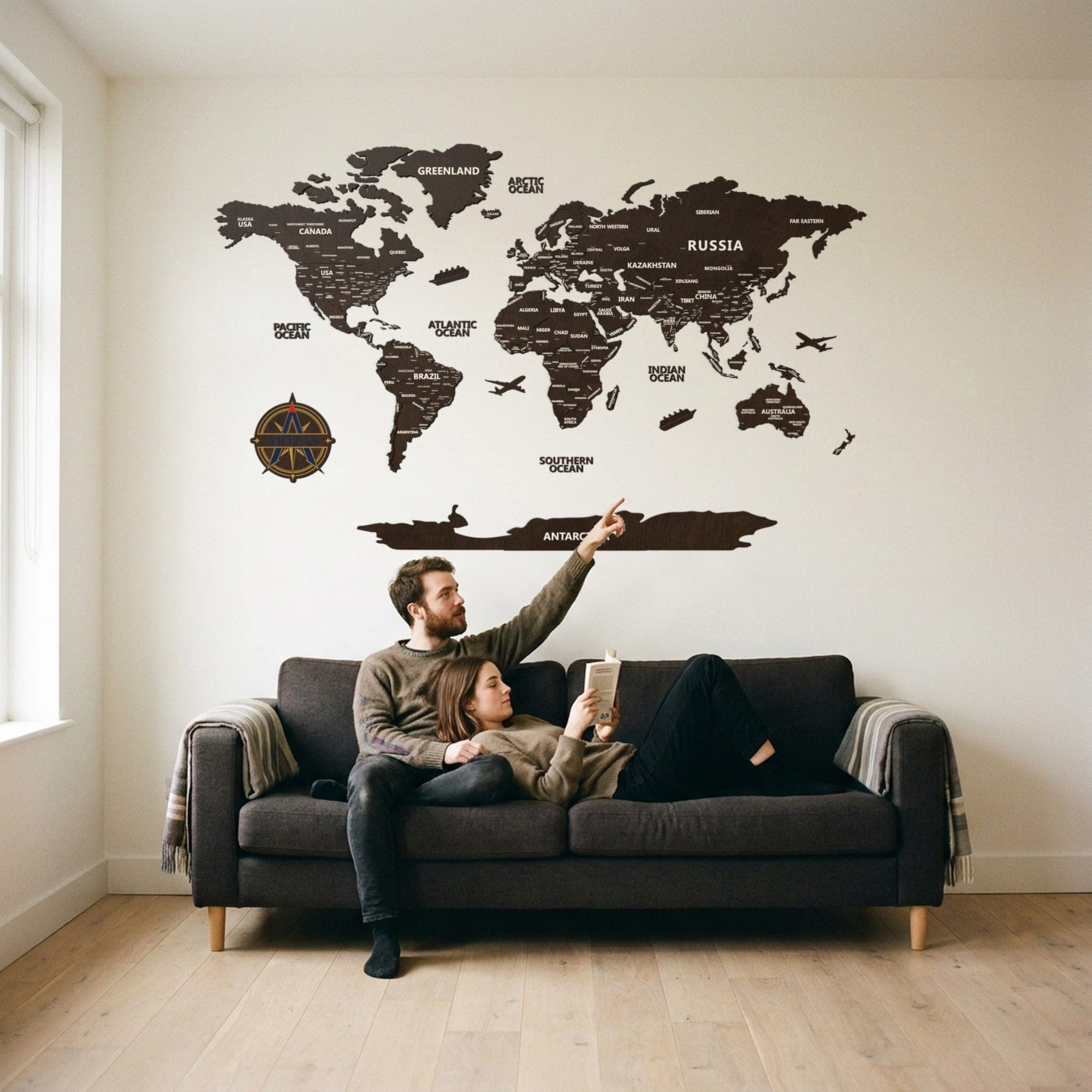 Two people on a sofa beneath the map in walnut
